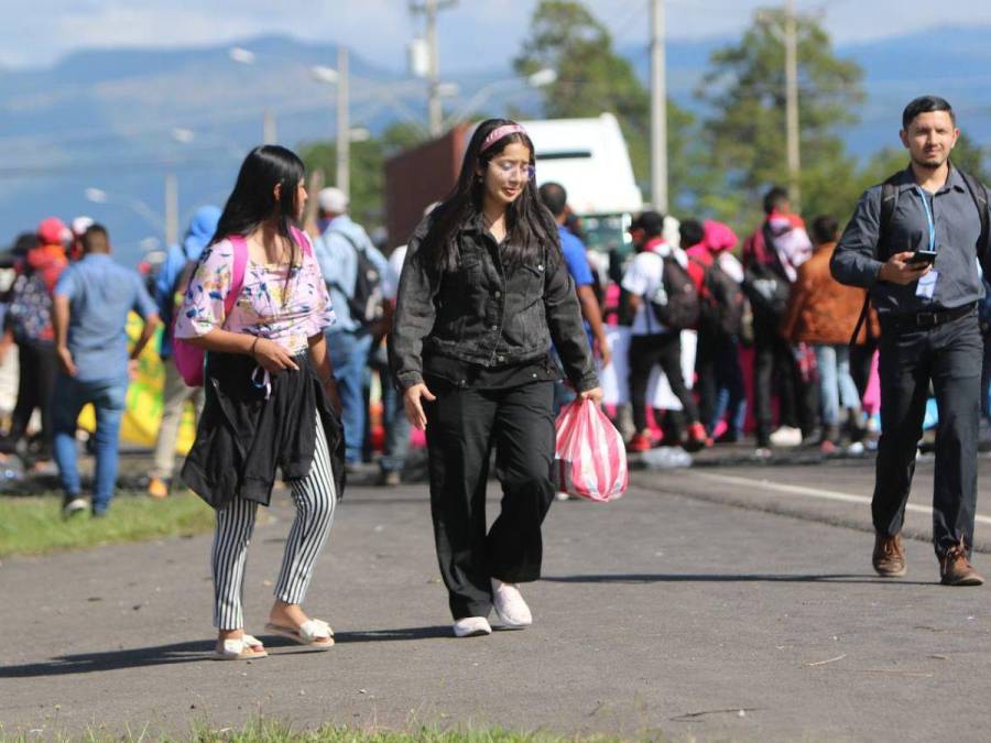 Con maleta en mano y niños en brazos, hondureños caminan por protesta en carretera CA-5