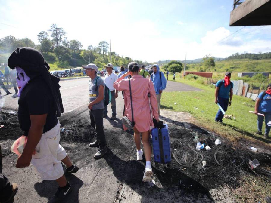 Con maleta en mano y niños en brazos, hondureños caminan por protesta en carretera CA-5