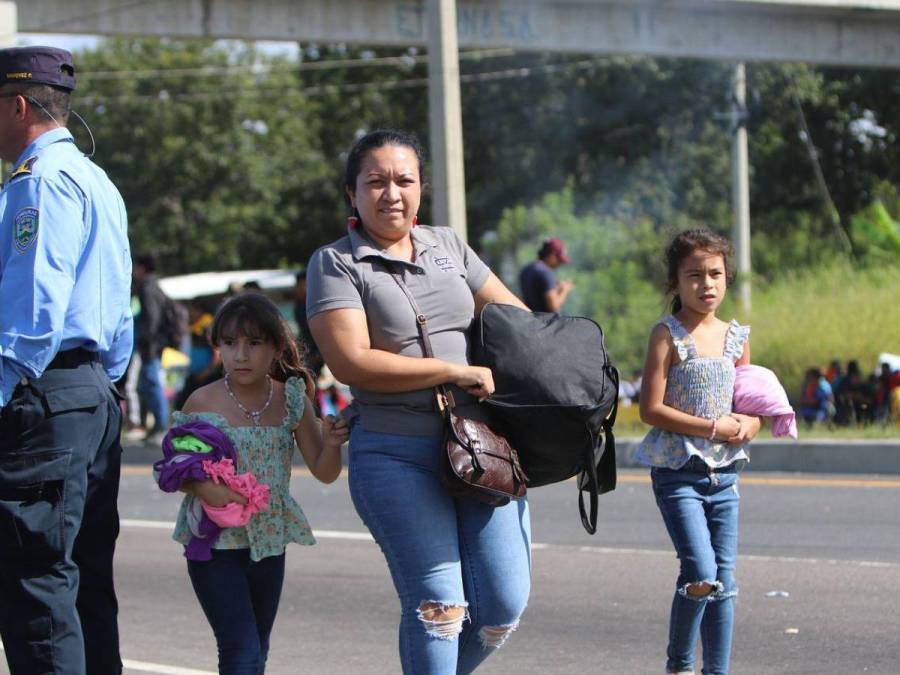 Con maleta en mano y niños en brazos, hondureños caminan por protesta en carretera CA-5