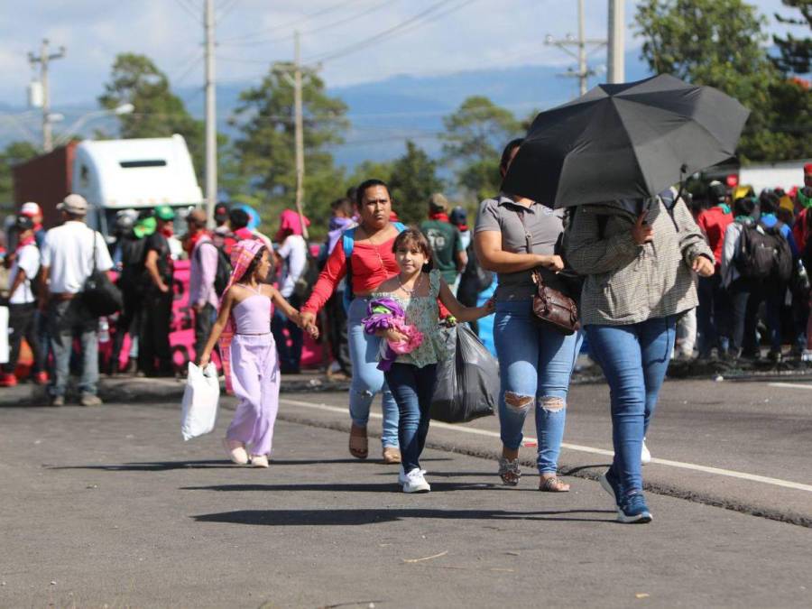 Con maleta en mano y niños en brazos, hondureños caminan por protesta en carretera CA-5