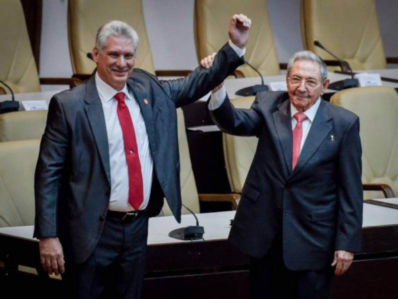 El presidente cubano saliente, Raúl Castro, levanta el brazo del nuevo presidente de Cuba, Miguel Díaz-Canel, después de haber sido nombrado formalmente por la Asamblea Nacional, en La Habana. Foto AFP