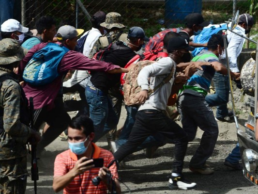 Momento en que caravana migrante rompe cerco policial e ingresa a Guatemala  